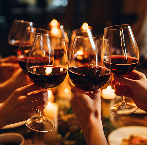 hands toasting with red wine glasses surrounded by candles celebrating togetherness and special moments six friends gathering