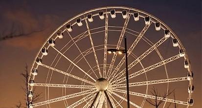 large illuminated Ferris wheel at dusk showcasing a beautiful skyline perfect for enjoying rides with friends and family two attractions
