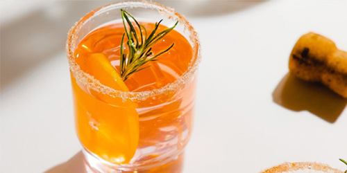 refreshing cocktail in a glass garnished with rosemary and a slice of orange perfect for gatherings of five